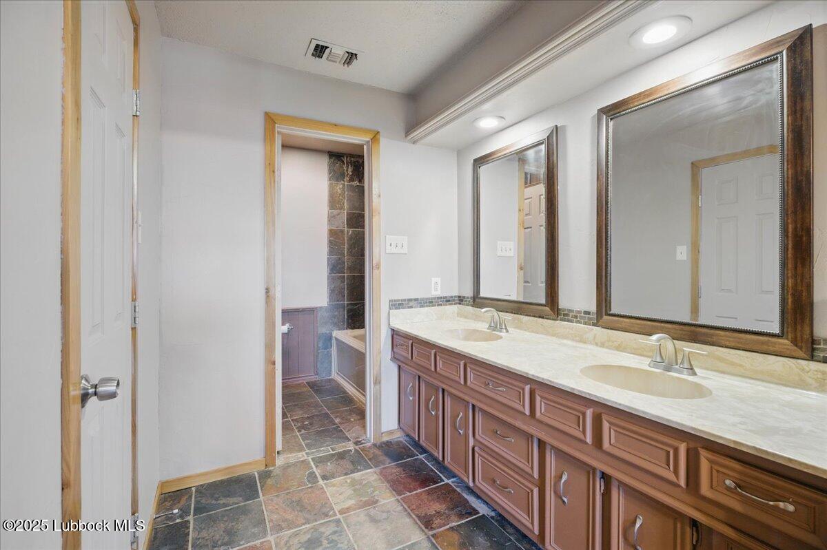 5726 67th Street Lubbock, TX 79424 - Photo 15 of 26 a bathroom with a granite countertop sink and a mirror