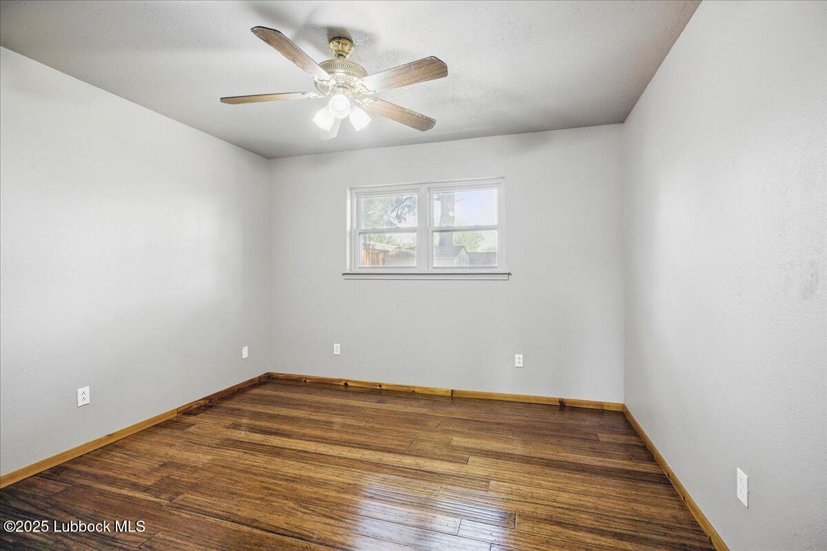5726 67th Street Lubbock, TX 79424 - Photo 17 of 26 an empty room with wooden floor and windows