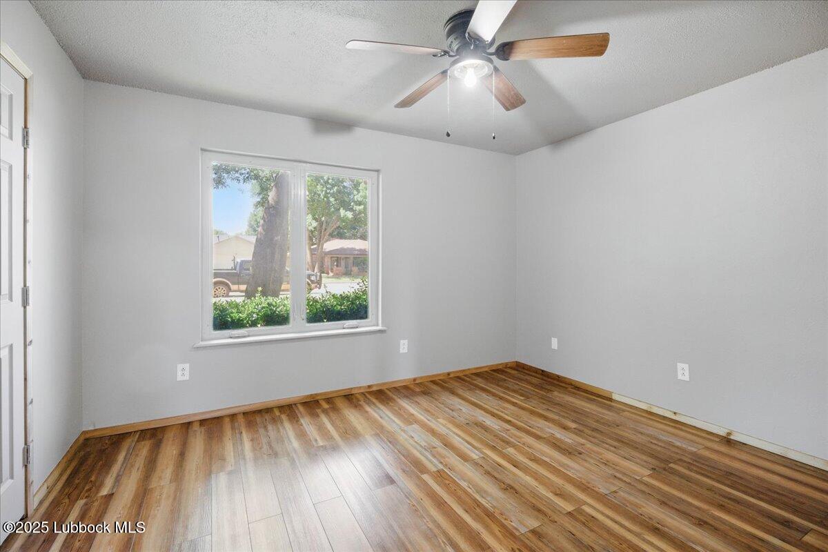 5726 67th Street Lubbock, TX 79424 - Photo 21 of 26 an empty room with a window and wooden floor
