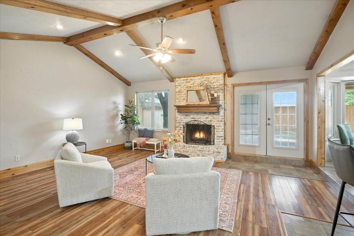 5726 67th Street Lubbock, TX 79424 - Photo 4 of 26 a living room with furniture a large window and a fireplace