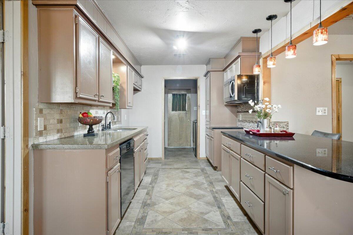 5726 67th Street Lubbock, TX 79424 - Photo 9 of 26 a kitchen with stainless steel appliances granite countertop a sink stove and cabinets