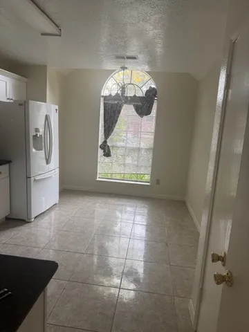 an empty room with a window and a fan