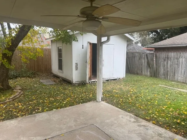 a view of an empty room with wooden floor and a fireplace