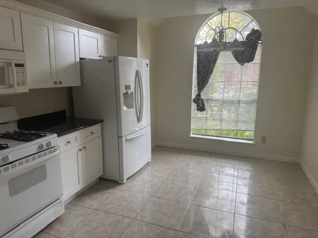 a kitchen with a refrigerator a stove a microwave and cabinets