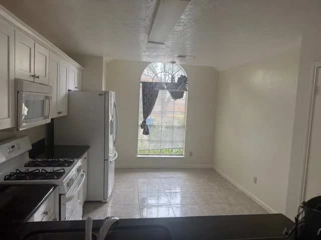 a kitchen with granite countertop a stove and a refrigerator