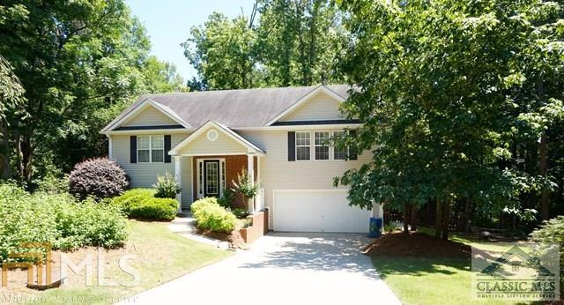 a view of a house with a small yard plants and large tree