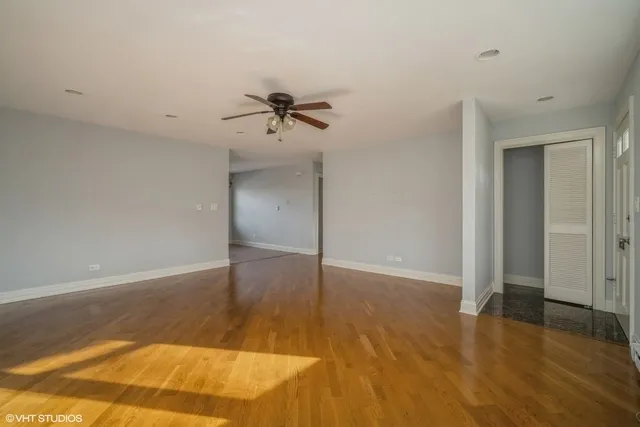 a view of a room with wooden floor and ceiling fan
