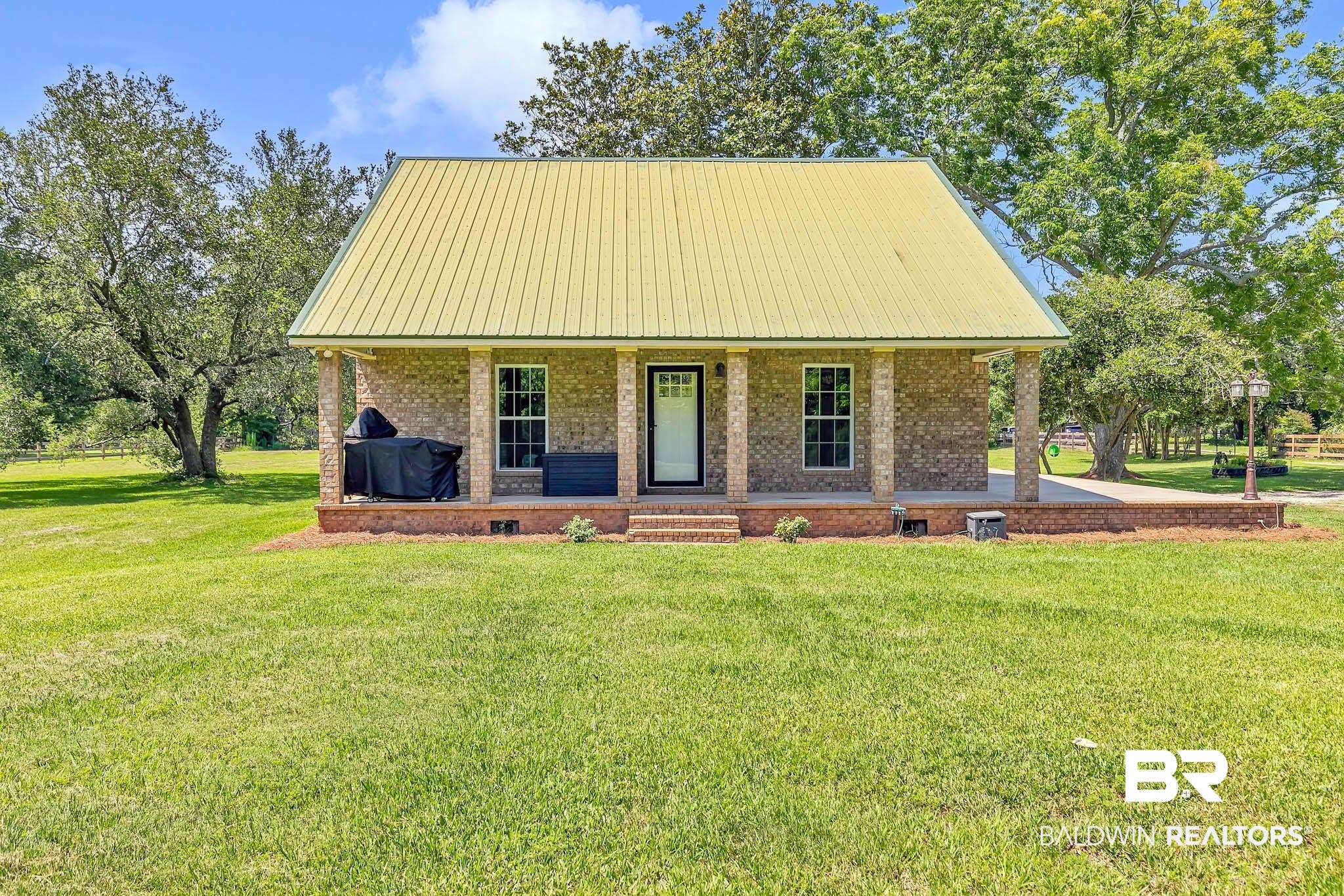 View of front of house with a porch, a front yard, and brick siding