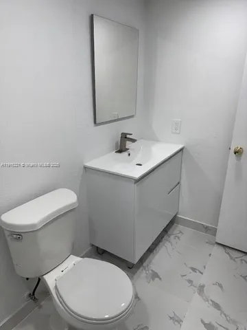 a white toilet sitting next to a bathroom sink