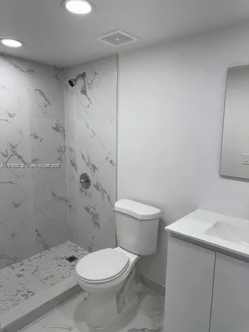 a white toilet sitting next to a bathroom sink