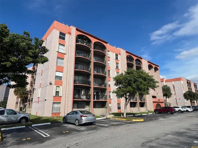 a view of a tennis ground with large trees