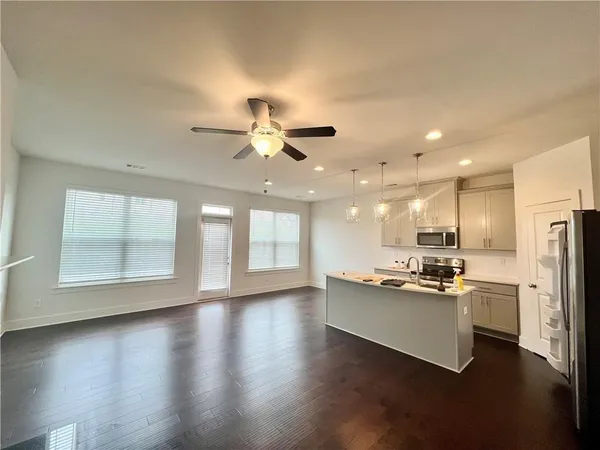 an open kitchen with kitchen island stainless steel appliances kitchen island hardwood floor and a window
