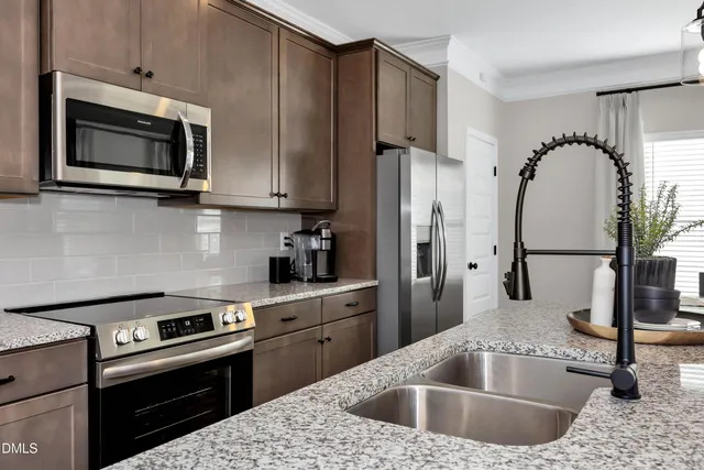 a kitchen with stainless steel appliances granite countertop a sink stove and refrigerator
