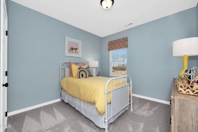 a bed sitting in a bedroom next to a lamp