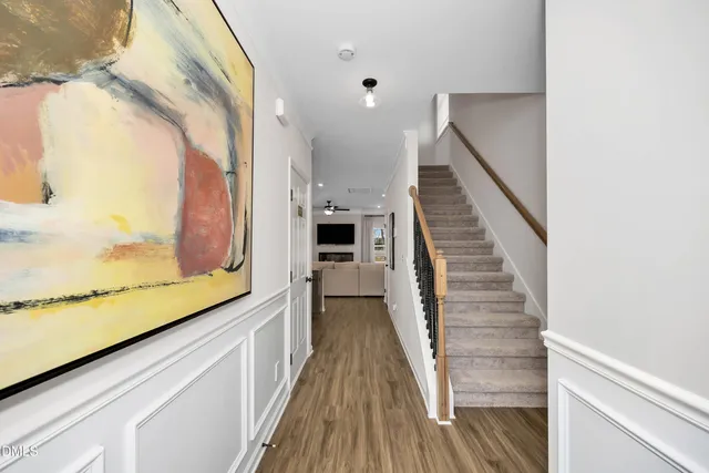 a view of a hallway with wooden floor and staircase