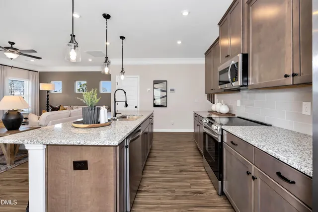 a kitchen with stainless steel appliances granite countertop a sink a stove and cabinets