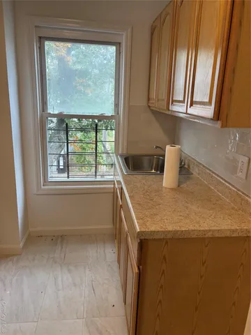 a kitchen with a sink a microwave a window and cabinets