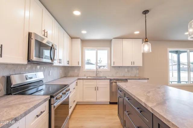 a kitchen with stainless steel appliances granite countertop a sink stove and cabinets