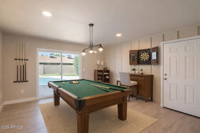 a room with pool table and chairs