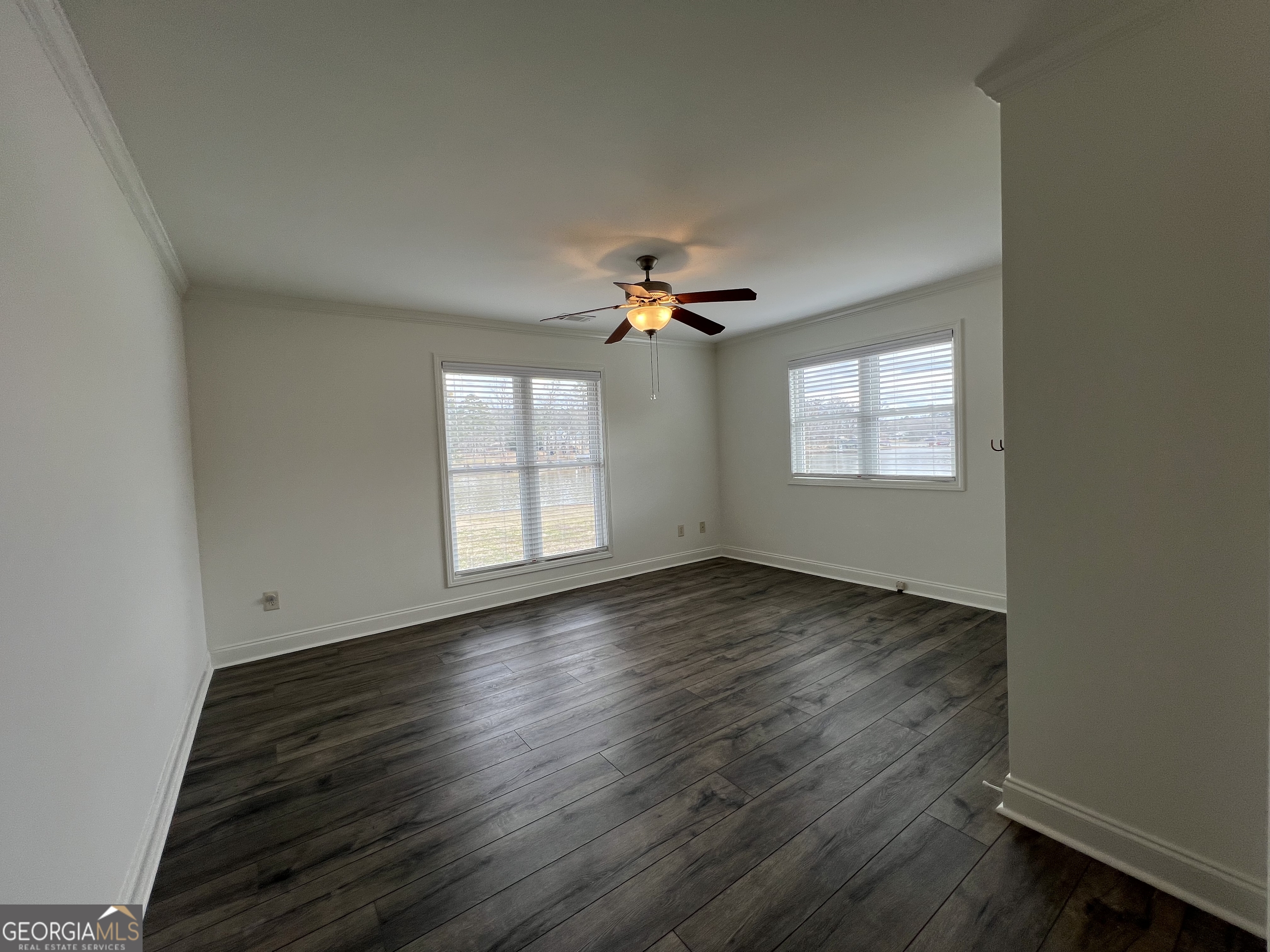 166 Montego Bay Road Northwest Milledgeville, GA 31061 - Photo 15 of 42 an empty room with wooden floor chandelier fan and windows