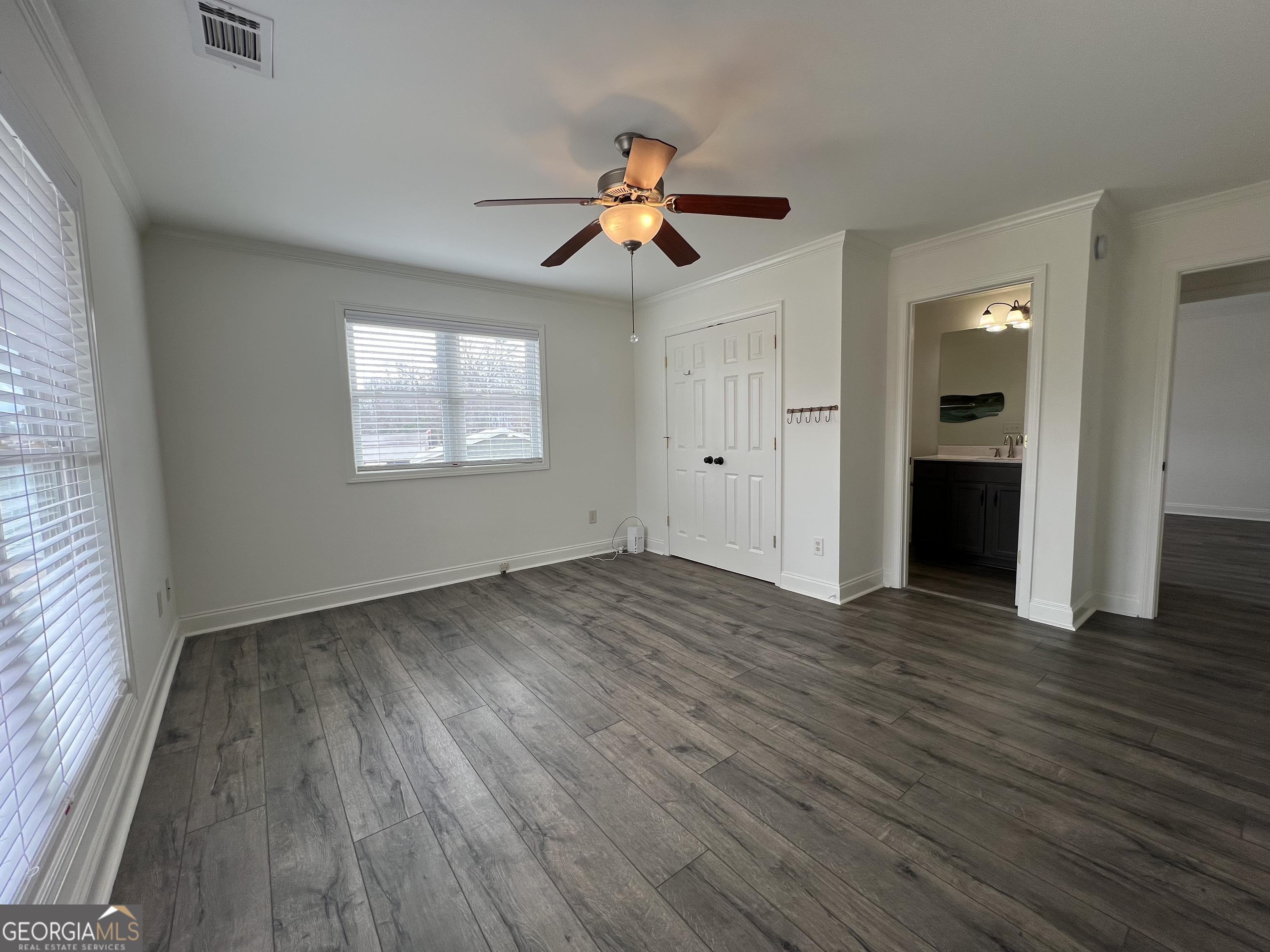 166 Montego Bay Road Northwest Milledgeville, GA 31061 - Photo 16 of 42 an empty room with wooden floor ceiling fan and windows