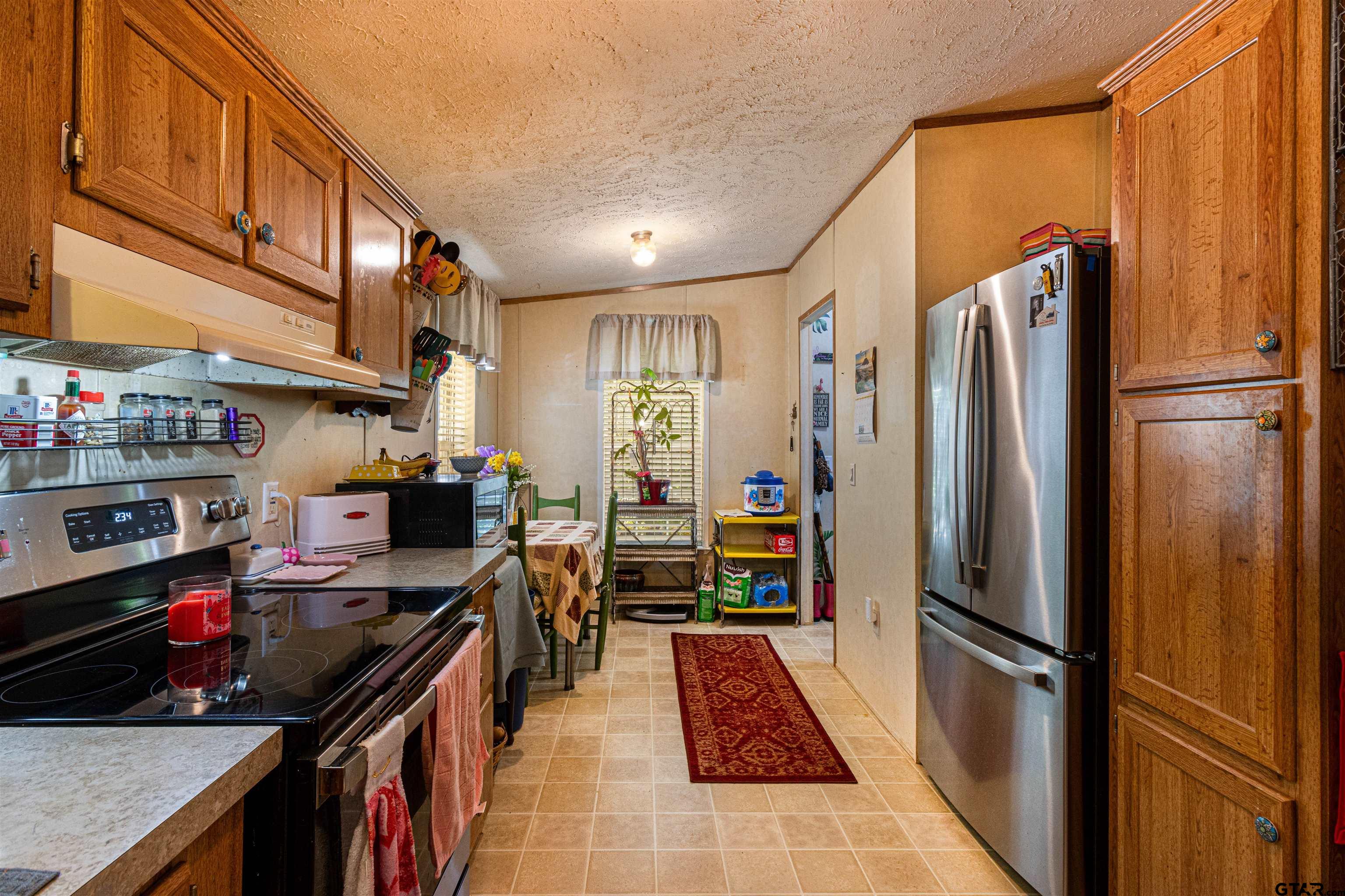 489 Martha Street Bullard, TX 75757 - Photo 19 of 44 a kitchen with stainless steel appliances a refrigerator a stove a sink and a refrigerator