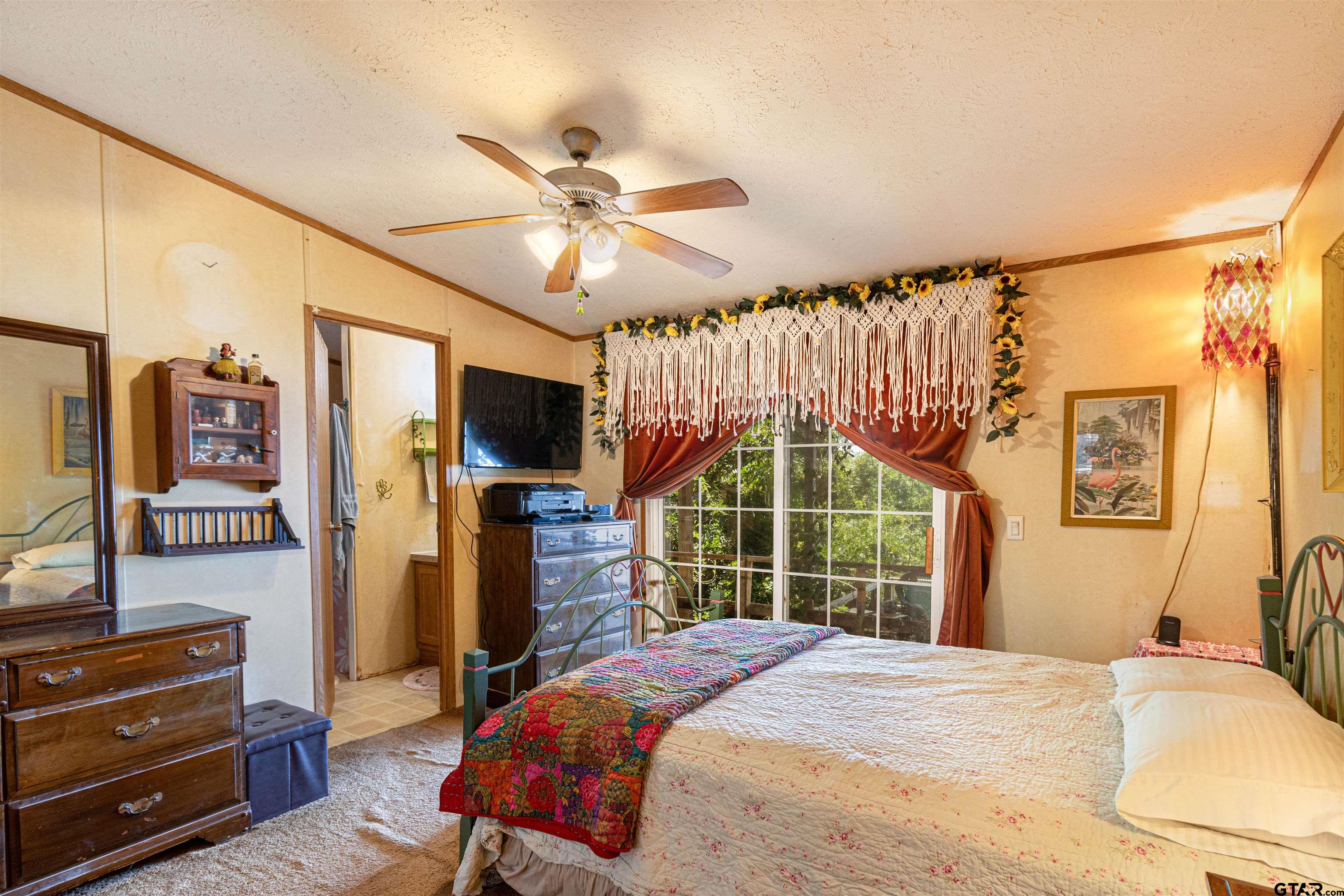 489 Martha Street Bullard, TX 75757 - Photo 29 of 44 a bedroom with a bed dresser and a flat tv screen