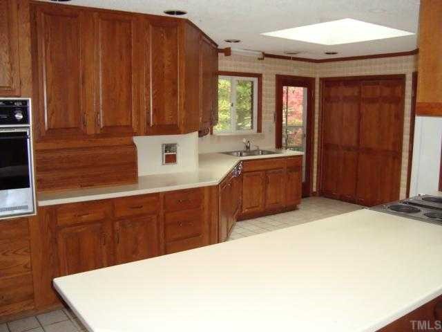 6414 King Lawrence Road Raleigh, NC 27607 - Photo 3 of 12 a kitchen with stainless steel appliances a sink cabinets and wooden floor