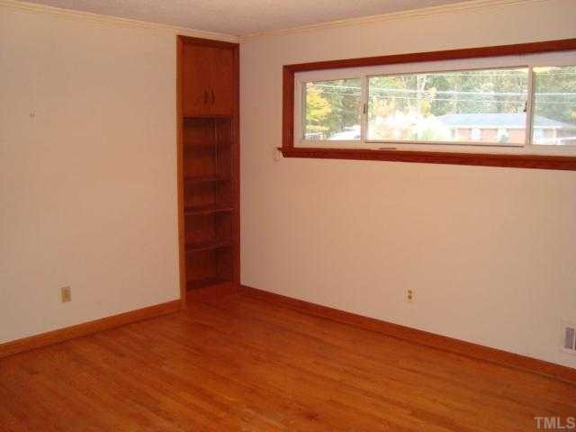 6414 King Lawrence Road Raleigh, NC 27607 - Photo 10 of 12 an empty room with wooden floor and windows
