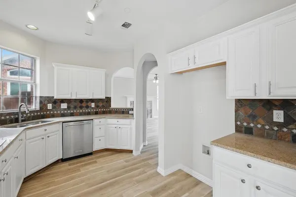 a kitchen with granite countertop a sink stove and refrigerator