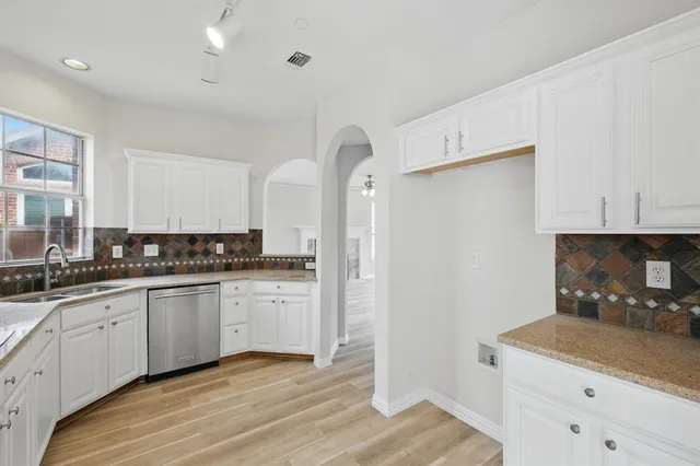a kitchen with granite countertop a sink stove and refrigerator