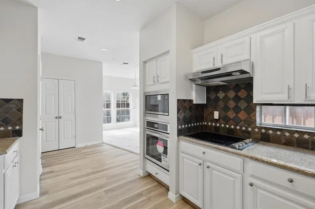 a kitchen with stainless steel appliances granite countertop a refrigerator and a stove top oven