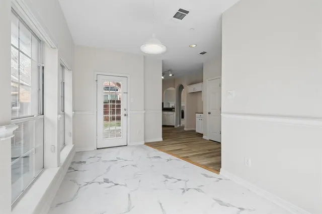 an empty room with wooden floor and windows