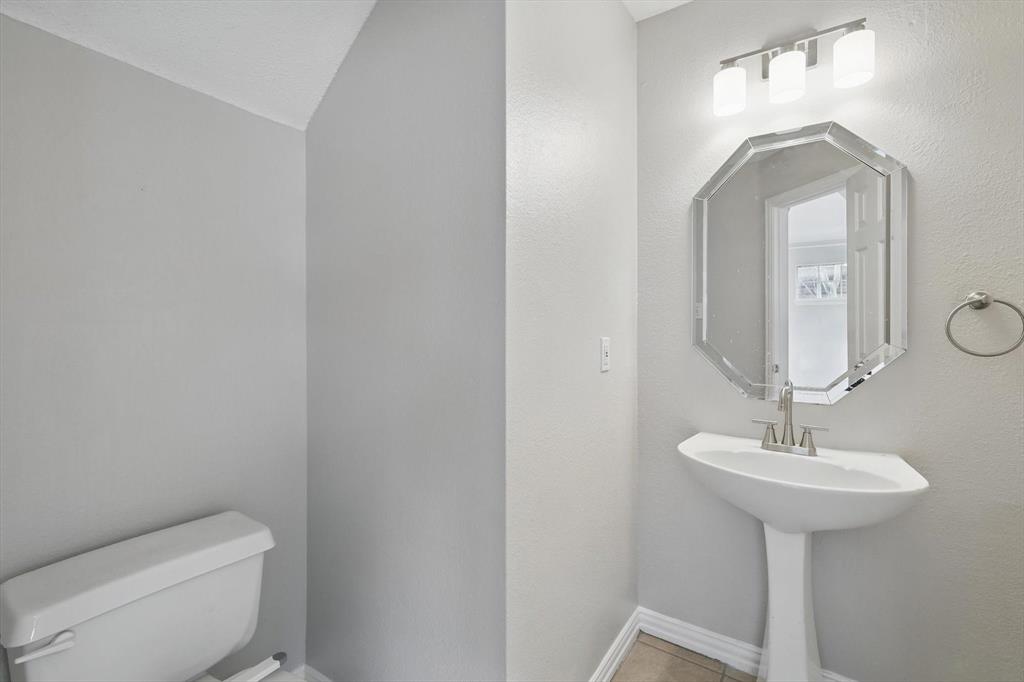 14625 Windsor Court Addison, TX 75001 - Photo 21 of 40 a bathroom with a toilet sink and mirror