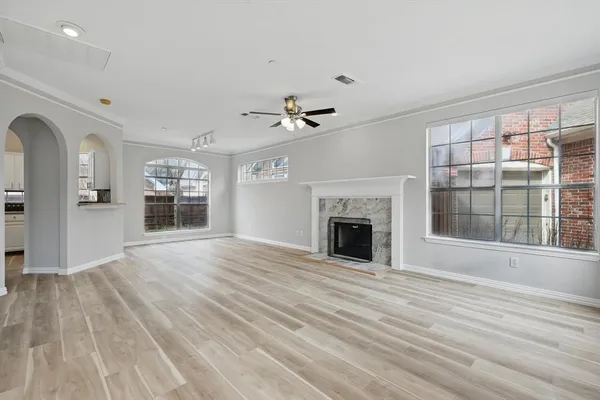 a view of an empty room with a fireplace and a window