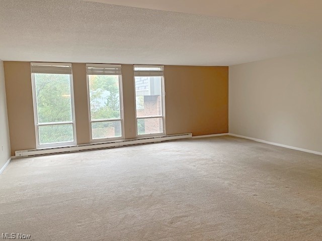 2385 Covington Road, Unit 302 Akron, OH 44313 - Photo 3 of 19 Carpeted spare room with a baseboard heating unit and a textured ceiling