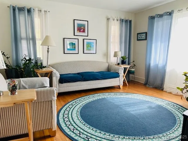 a living room with furniture and a wooden floor