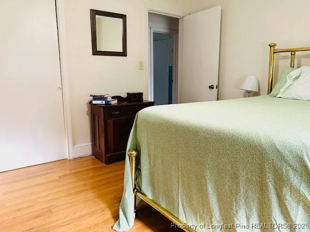 a bedroom with a bed and wooden floor