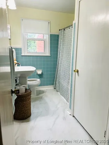 a bathroom with a toilet a sink and a shower