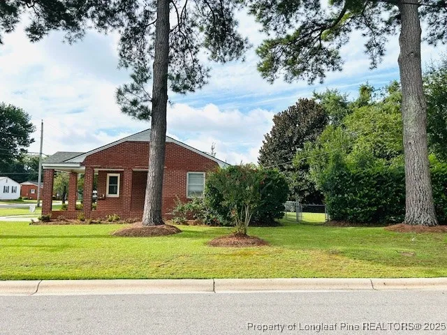 a front view of house with yard and trees
