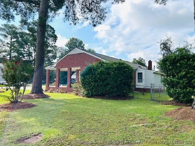 a view of a house with a yard and sitting area