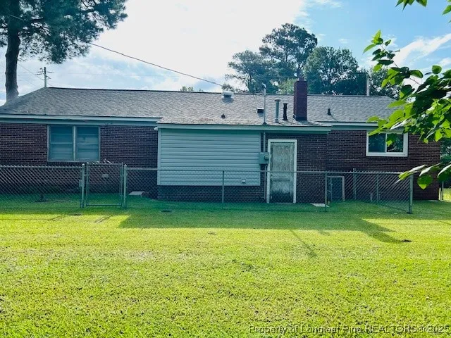 a view of a backyard with plants and a large tree
