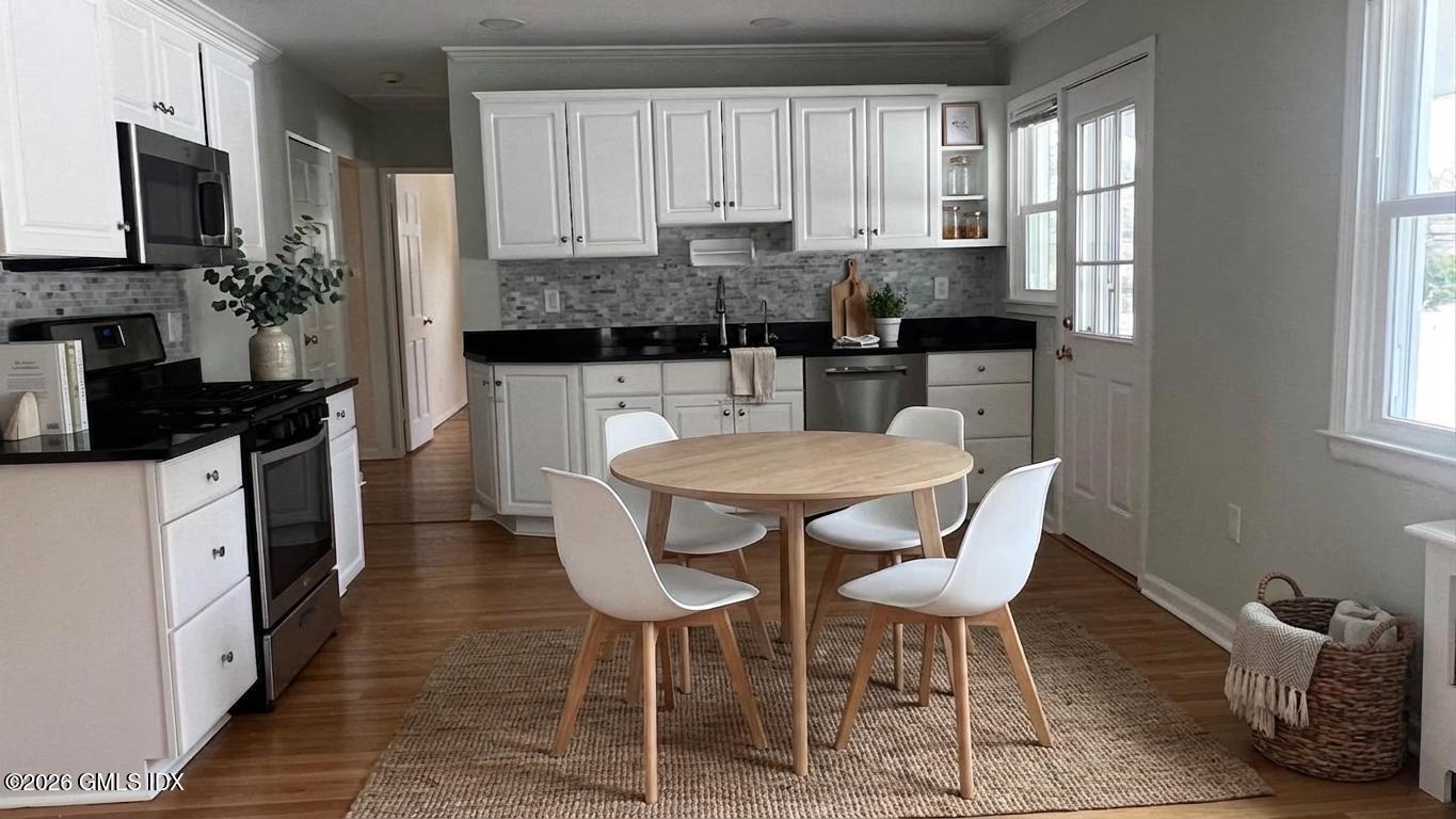 45 Sound Beach Ave Extension Riverside, CT 06878 - Photo 3 of 11 a kitchen with a table chairs microwave and cabinets