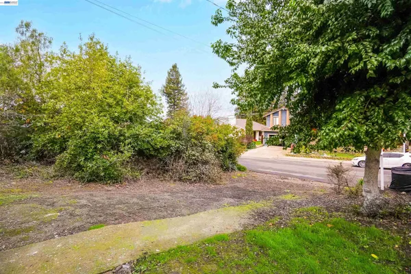 a view of a house with a yard and road