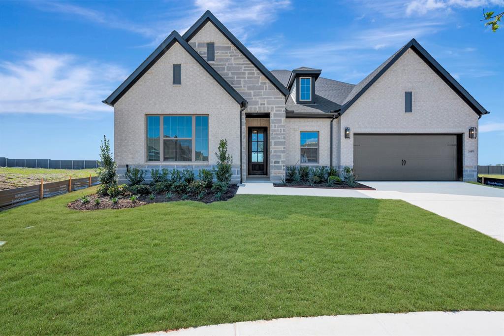 View of front facade featuring stone siding, driveway, brick siding, and an attached garage