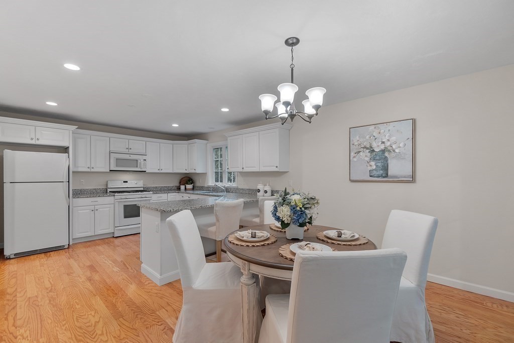 3 Reed Lane, Unit 3 Littleton, MA 01460 - Photo 8 of 29 a kitchen with stainless steel appliances a dining table chairs and white cabinets