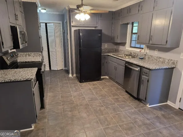 a kitchen with stainless steel appliances granite countertop a refrigerator a stove and a sink