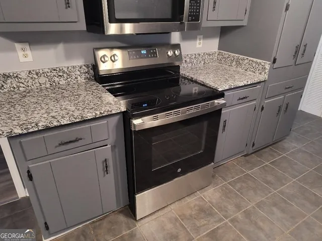 a stove top oven sitting inside of a kitchen