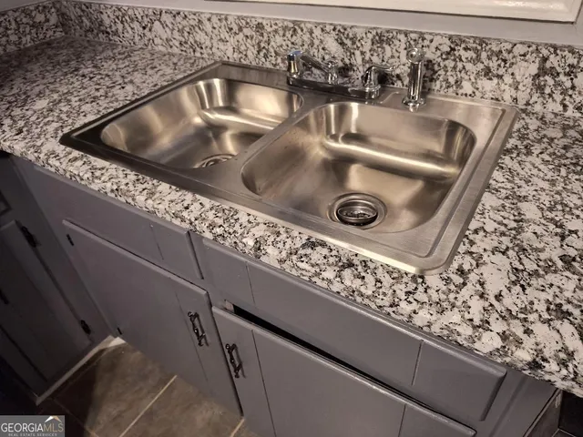 an empty room with wooden floor fireplace and windows