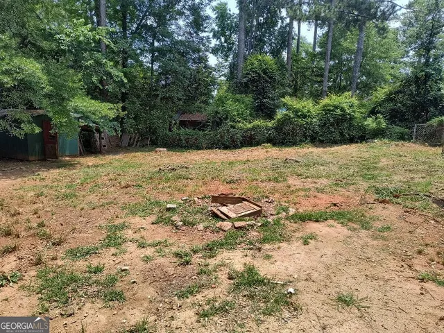 a view of a house with backyard and a trees
